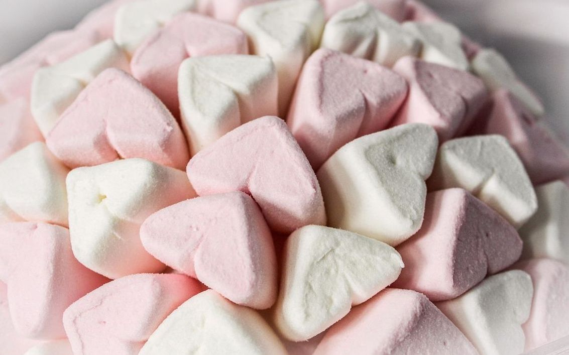 Un frasco de gomitas de fresa caseras con luz natural de fondo